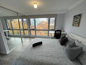 a bedroom with a large bed and a large window at Private room with ensuite in the CBD in Canberra