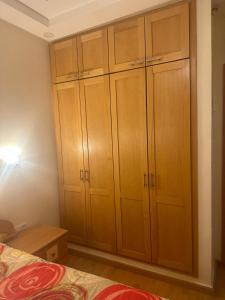 a bedroom with wooden cabinets and a bed at Appartement familial agadir in Agadir