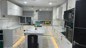 a large kitchen with white cabinets and a counter at 001 Apartments in Oshogbo