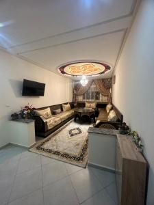 - un salon avec un canapé et une table dans l'établissement Appartement familial agadir, à Agadir