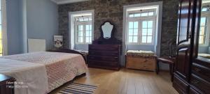 a bedroom with a bed and a dresser and windows at Casa do Amigo in Seixal