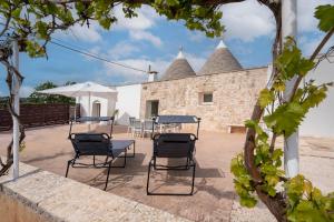 a patio with chairs and tables in front of a building at Trulli Miriam: Enchanting Apulian Getaway in Martina Franca