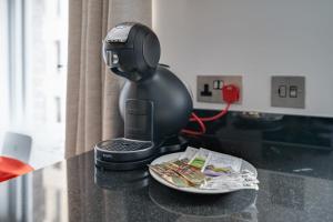 a black controller sitting on a counter next to a plate at Lovely Charing Cross Apartment in London