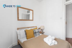 - une chambre avec un lit et un miroir mural dans l'établissement 2 Bed Apartment - 7 min walk Train Station, à Édimbourg