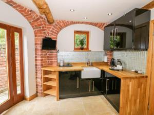 a kitchen with a sink and a brick wall at The Hyde Dovecote Kinver pet friendly holiday let in Stourbridge