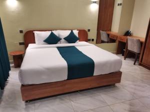 a bedroom with a large bed with blue pillows at HAVEN STAY HOTEL in Eldoret