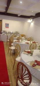 ein Zimmer mit Tischen und Stühlen mit weißen Tischdecken in der Unterkunft HAVEN STAY HOTEL in Eldoret
