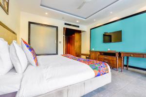 a bedroom with a bed and a desk and a television at FabHotel Prime The King's Court Calangute with Pool and Bar in Calangute
