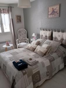 um quarto com uma cama grande e uma cadeira em la maison rose 2 chambres a louer avec lits 2 personnes em Nevers