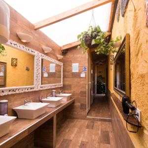 een badkamer met vier wastafels en een rij spiegels bij Hostel Los Amigos by Youroom in La Mareta
