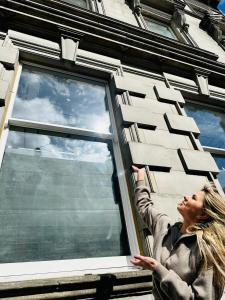 Una mujer está mirando por una ventana en Barnet House Serviced Apartments, en Fife