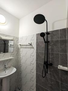 a bathroom with a shower with a black light on the wall at Chambre meublée cosy à Yaoundé in Yaoundé