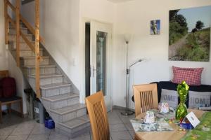ein Wohnzimmer mit einem Tisch und einer Treppe in der Unterkunft Gemütliche Maisonette-Wohnung mit Fußbodenheizung in Berndorf