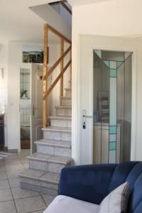 ein Wohnzimmer mit einem blauen Sofa und einer Treppe in der Unterkunft Gemütliche Maisonette-Wohnung mit Fußbodenheizung in Berndorf