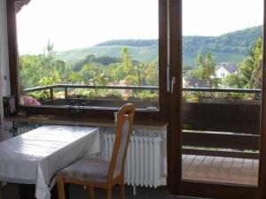 Zimmer mit einem Tisch und einem Balkon mit Aussicht in der Unterkunft Vogesen-Wohnung mit Balkon 2-Zi-Fewo 67qm mit herrlichem BurgVogesen-Blick neben Schlosspark Nahe in Badenweiler