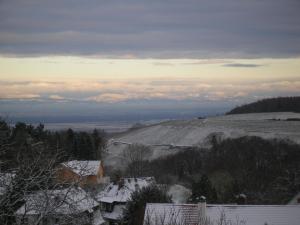 Blick auf ein schneebedecktes Feld mit Bergen in der Ferne in der Unterkunft Vogesen-Wohnung mit Balkon 2-Zi-Fewo 67qm mit herrlichem BurgVogesen-Blick neben Schlosspark Nahe in Badenweiler