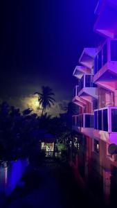 a night view of a building and a palm tree at Hotel Vista Sur in Los Patos