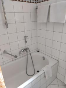 La salle de bains est pourvue d'une baignoire et d'une douche. dans l'établissement Apartment Bayrischer Wald am Golfclub im Feriendorf Glasgarten, à Rötz