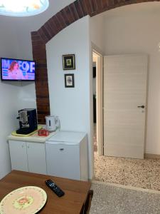 eine Küche mit einem Kühlschrank und einem Tisch mit einem TV in der Unterkunft Agriturismo cerquatonda B&B in Montalto delle Marche