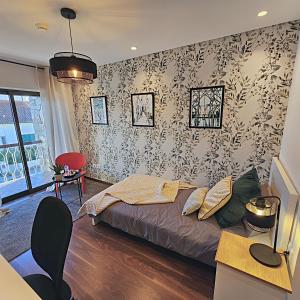 una camera con letto e parete con carta da parati di Casa Vincente Suite-Coimbra University 1Km- 20 m2 a Coimbra