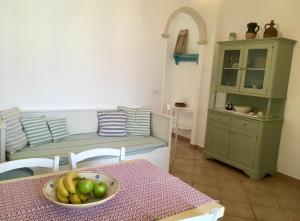 una cocina con mesa y un bol de fruta en CASE VACANZE 'RICCIO E SALVIA' A S. M. DI LEUCA, en Marina di Leuca