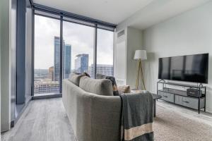 a living room with a couch and a large window at Blueground Downtown pool gym wd near food ATX-256 in Austin