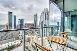 a balcony with a wooden bench and a view of the city at Blueground Downtown pool gym wd near food ATX-256 in Austin