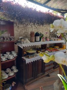 eine Küche mit einem Buffet mit Speisen und Geschirr in der Unterkunft Pousada Rosa de Saron in Holambra