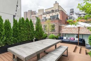 a patio with a table and benches on a roof at Blueground Tribeca terrace near Battery Park NYC-1490 in New York
