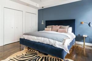 Dormitorio azul con cama grande y alfombra de cebra en Blueground Tribeca terrace near Battery Park NYC-1490 en Nueva York