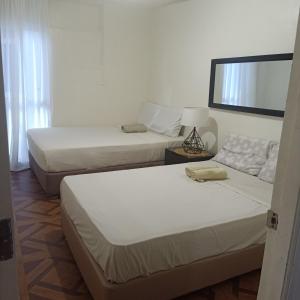 a bedroom with two beds and a mirror at Affordable Makati APT in Manila