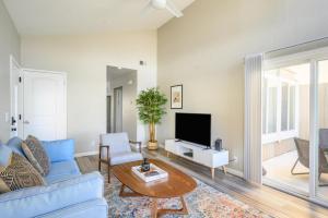uma sala de estar com um sofá azul e uma televisão em Foster City 2br w pool balcony nr parks SFO-1515 em Foster City