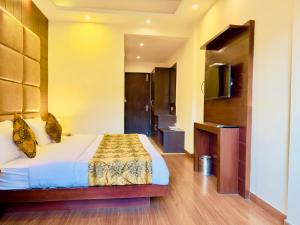 Gampi Villa في Bharuch: غرفه فندقيه سرير وتلفزيون