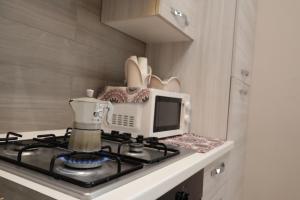 een keuken met een fornuis en een magnetron bij Villa Sorge Apartments in San Giorgio a Cremano