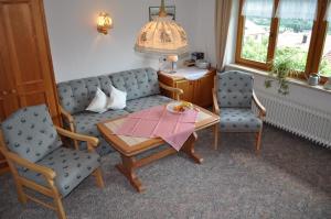 a living room with a couch and two chairs and a table at Haus Zillach in Bad Hindelang