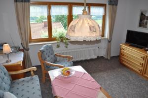 sala de estar con mesa, sillas y ventana en Haus Zillach, en Bad Hindelang