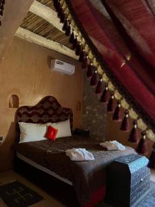 una camera da letto con un letto e asciugamani di Palais D'Ouzoud ad Azilal