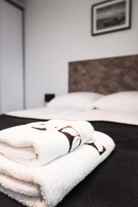 two beds with white towels in a room at Nette Wohnung in Poddbie mit Garten, Grill und gemeinschaftlichem Pool und Strand in der Nähe in Poddąbie