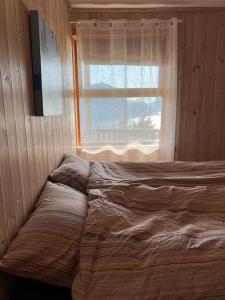 un letto non rifatto in una camera da letto con finestra di Panorama appartement a Volda