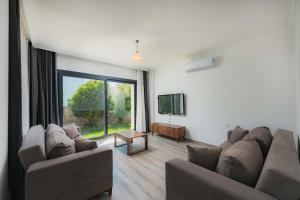 a living room with a couch and a flat screen tv at Ben Houses Family in Bodrum City