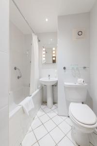 a white bathroom with a toilet and a sink at Normandy Hotel (Near Glasgow Airport) in Paisley