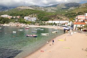 a group of people on a beach with boats in the water at Apartment Pržno in Pržno
