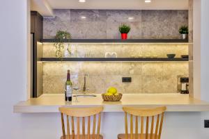 a kitchen with a counter with two chairs and a sink at Sole Suites in Kas