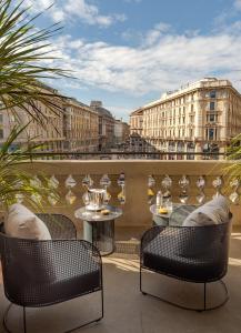 a balcony with two chairs and a table on a balcony at Palazzo Cordusio, a Gran Melia Hotel in Milan