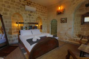 um quarto com uma cama num quarto com paredes de pedra em Şems Inn em Mardin