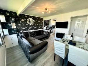a living room with a couch and a table at Family Chalets - 5 mins walk to beach, nr Great Yarmouth & Norfolk Broads in Scratby