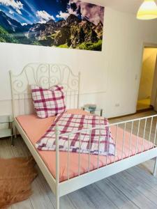 Cama blanca con sábanas rosas y almohadas en una habitación en Wohnung Zentrum Albstadt, en Albstadt