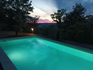 a blue swimming pool with a sunset in the background at Casa de Ferrapilhe in Paranhos