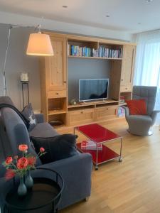 - un salon avec un canapé et une télévision dans l'établissement ZISA Ferienwohnung Bodensee, à Friedrichshafen