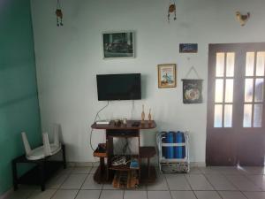 sala de estar con TV y suelo de baldosa. en Casa no atalaia na rua atalho, en Salinópolis